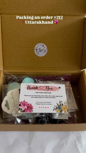 An open kraft box from PS Creation with scrunchies and a thank-you card, packed for Uttarakhand